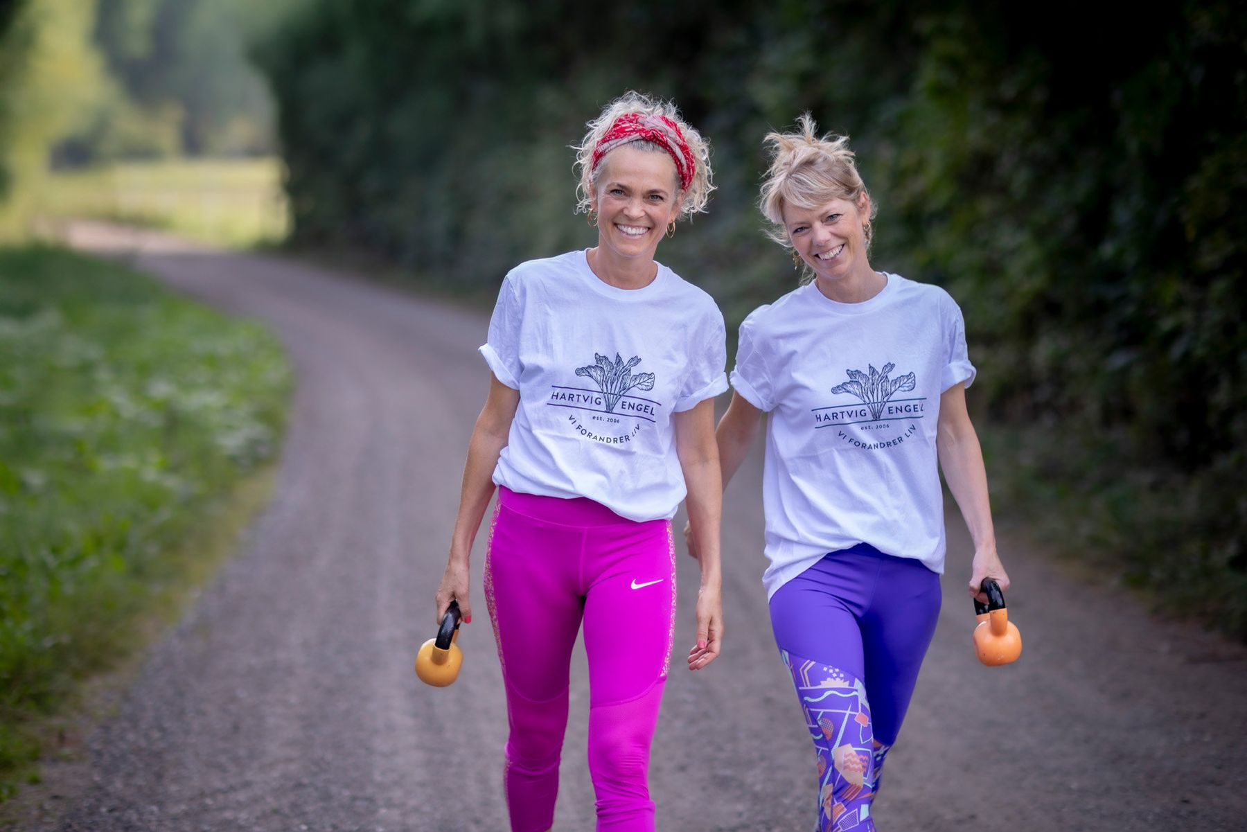 Alice og Majbritt går på en sti med kettlebells